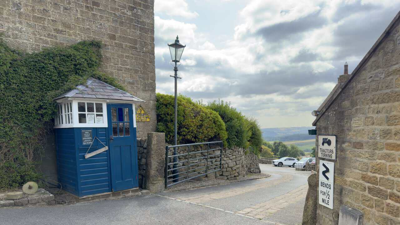 Restored blue police box standing beside the route through Tiplady Farm.