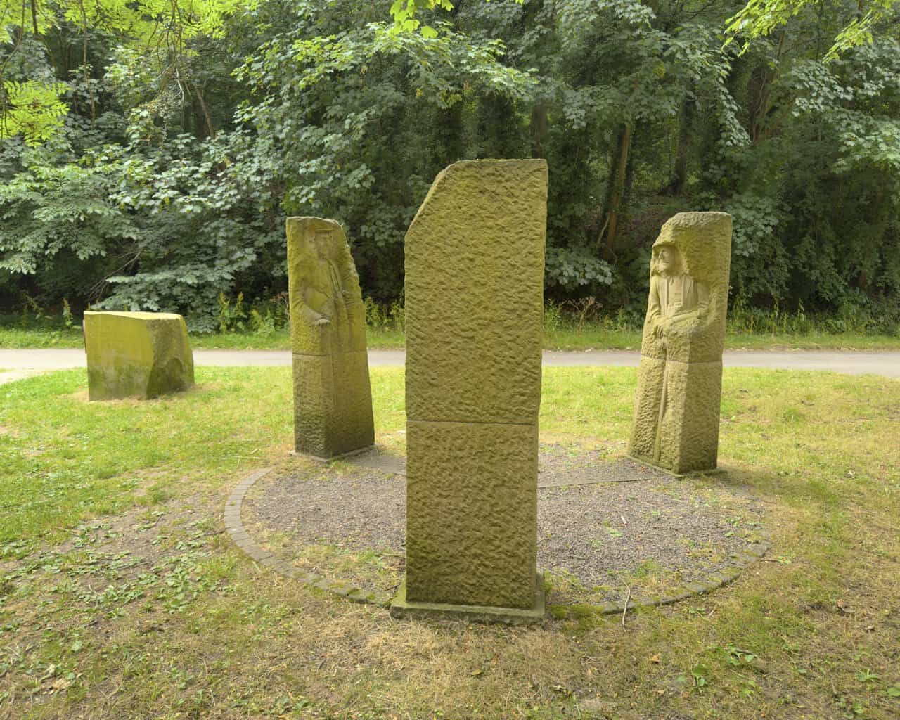 Pillars Past sandstone sculptures arranged in a circle beside the Way of the Roses cycle route.