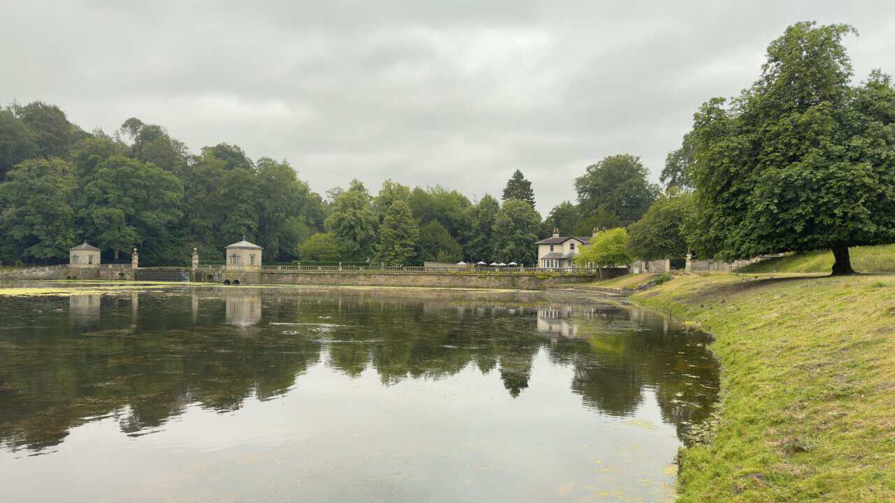 Studley Lake looking towards the dam, with the two fishing tabernacles and a cascade spilling down between them.
