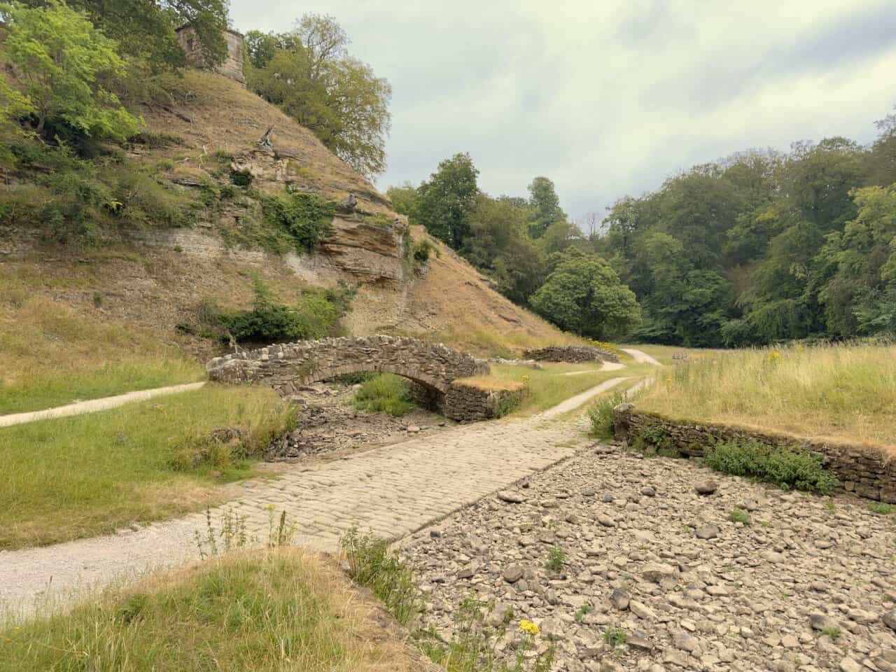 The second and third stone bridges beside a cobbled ford, with the Roman Monument, or Devil's Chimney, high on the ridge above.