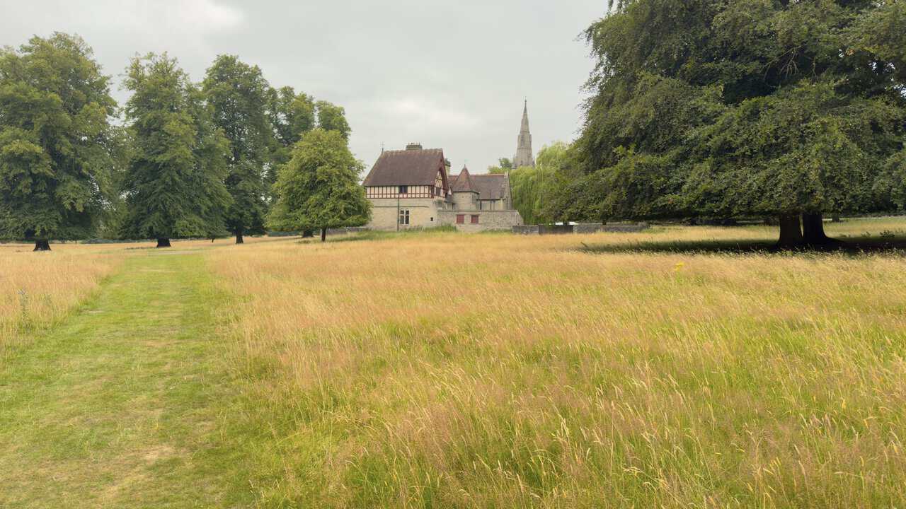 Choristers' House coming into view ahead, the spire of St Mary's Church rising above the trees beyond it.
