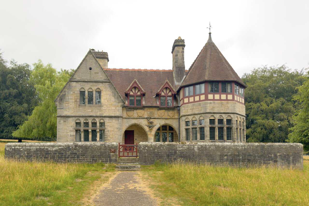 The twin-arched stone porch of Choristers' House, carved above with heraldic shields and the stag badge of Lord Ripon.
