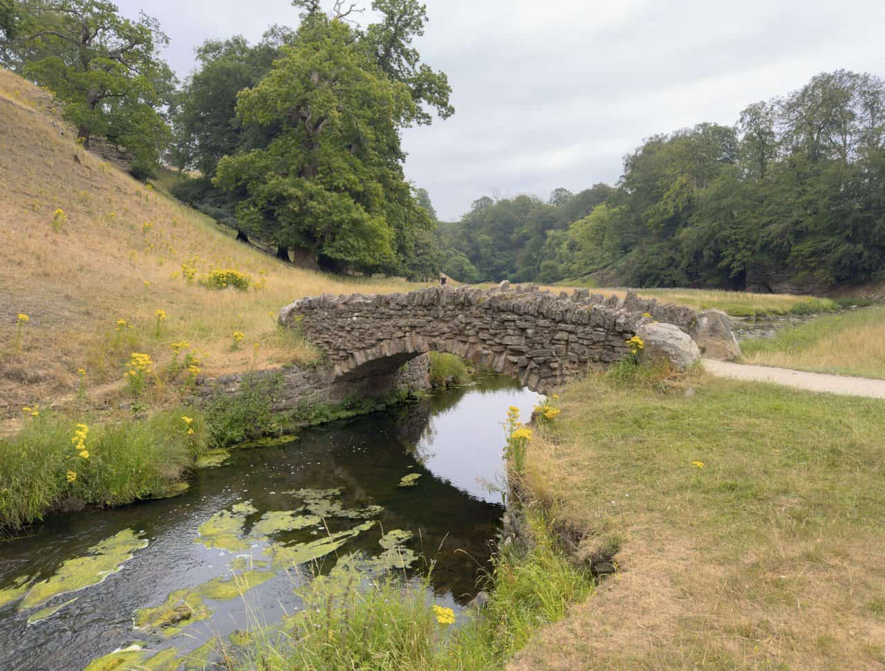 The first arched stone bridge carrying the path over the River Skell in the Seven Bridges Valley.
