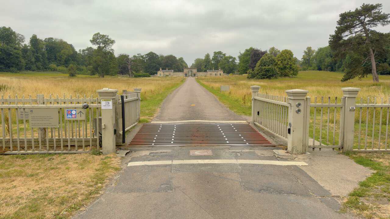 The gated entrance to Studley Royal, with a straight drive running through the deer park to a stone archway, a highlight of the Fountains Abbey walk.