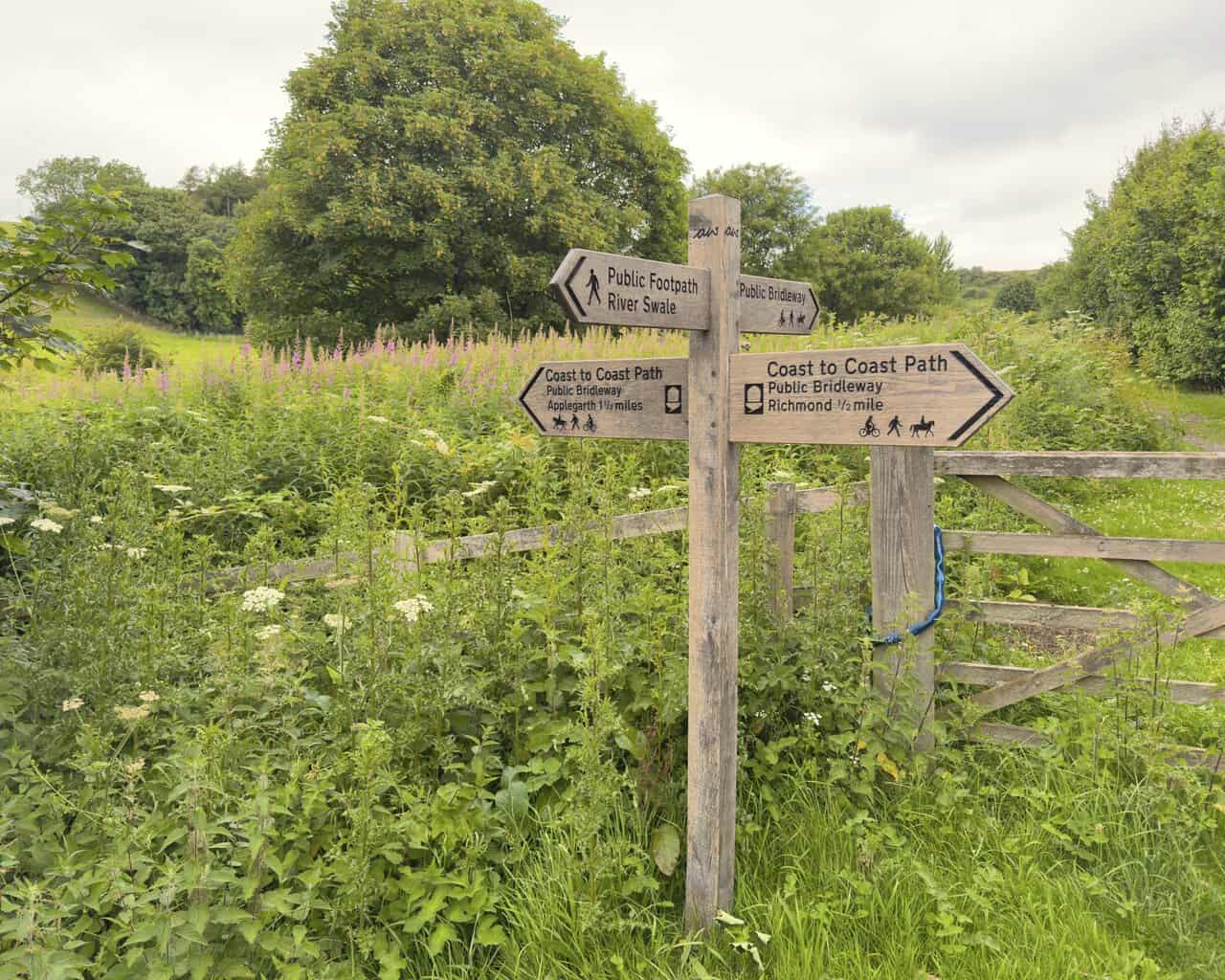 Wooden Coast to Coast Path signpost near Westfields on the Richmond walk, showing directions to Richmond and Applegarth.