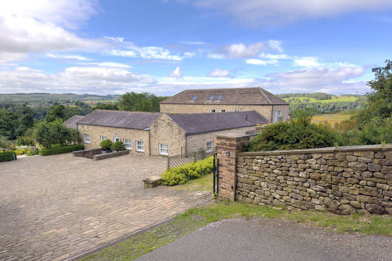 Restored stone buildings at High Leases on the Richmond walk, with slate roofs, cobbled yard and open countryside beyond.