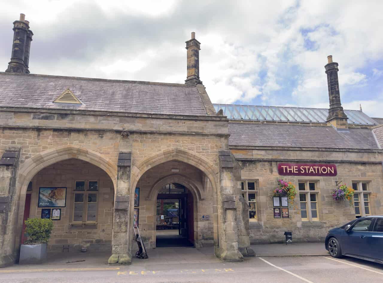 Former Richmond railway station building beside the River Swale, with Victorian stonework, steep gables and tall chimneys.