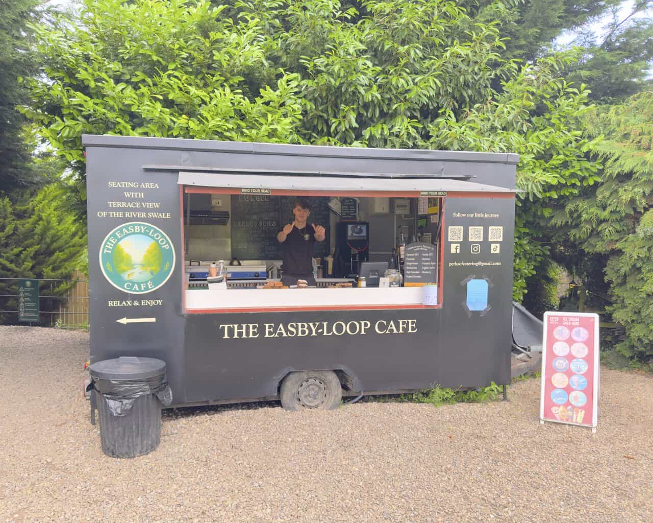 Easby Loop café on the Richmond walk, with a painted catering trailer, outdoor seating and views towards the River Swale.