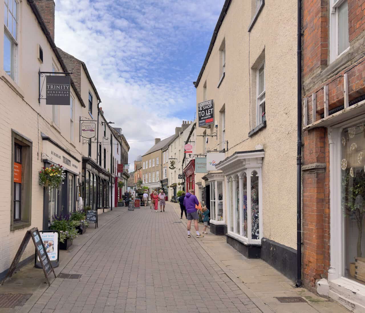 Finkle Street on the Richmond walk, lined with independent shops, cafés, hanging signs and flower baskets.