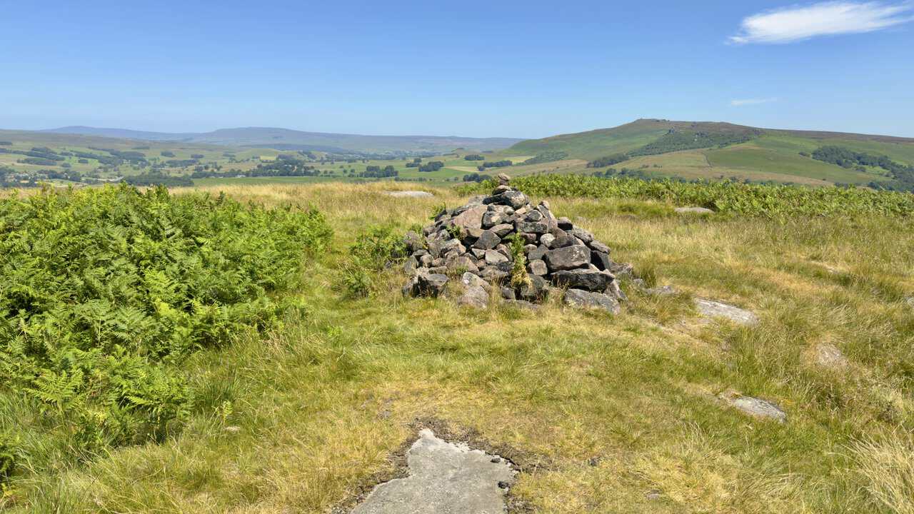 Summit cairn on Rough Haw at 339 metres on the Skipton walk, with the fells of the Dales beyond.