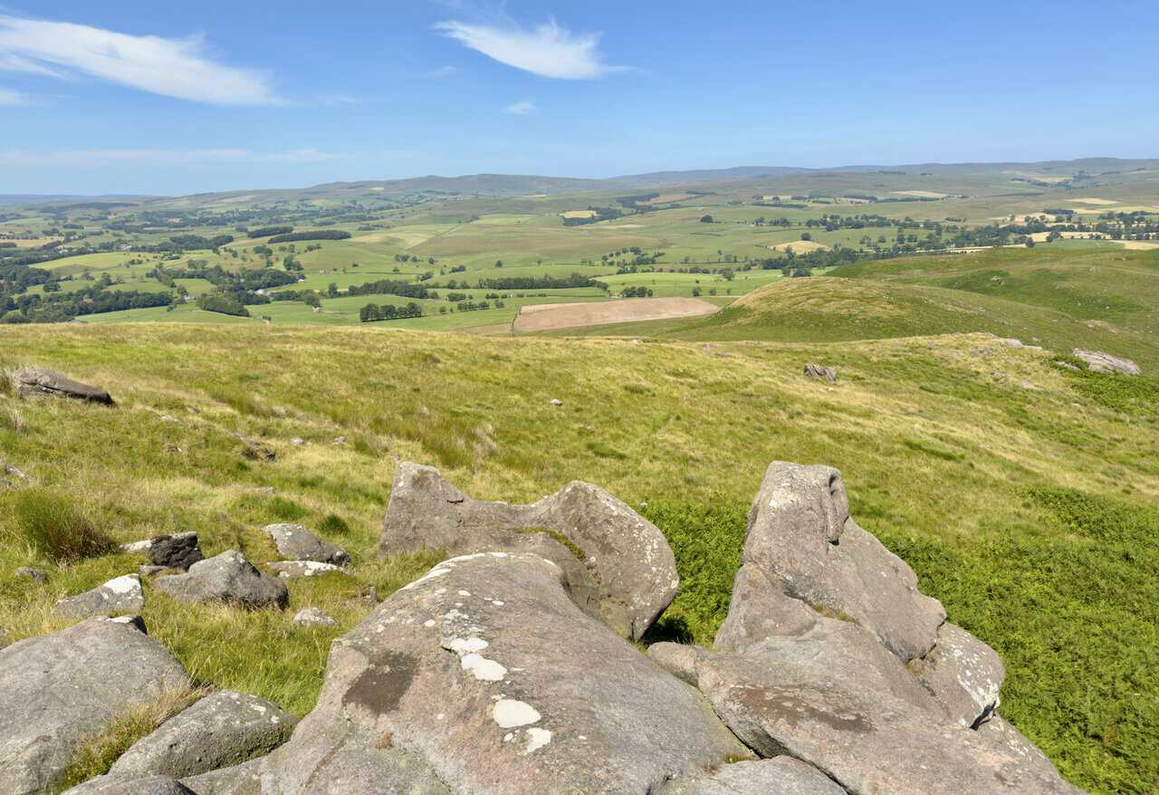 View from the boulders on Rough Haw across pasture and woodland towards Airedale.
