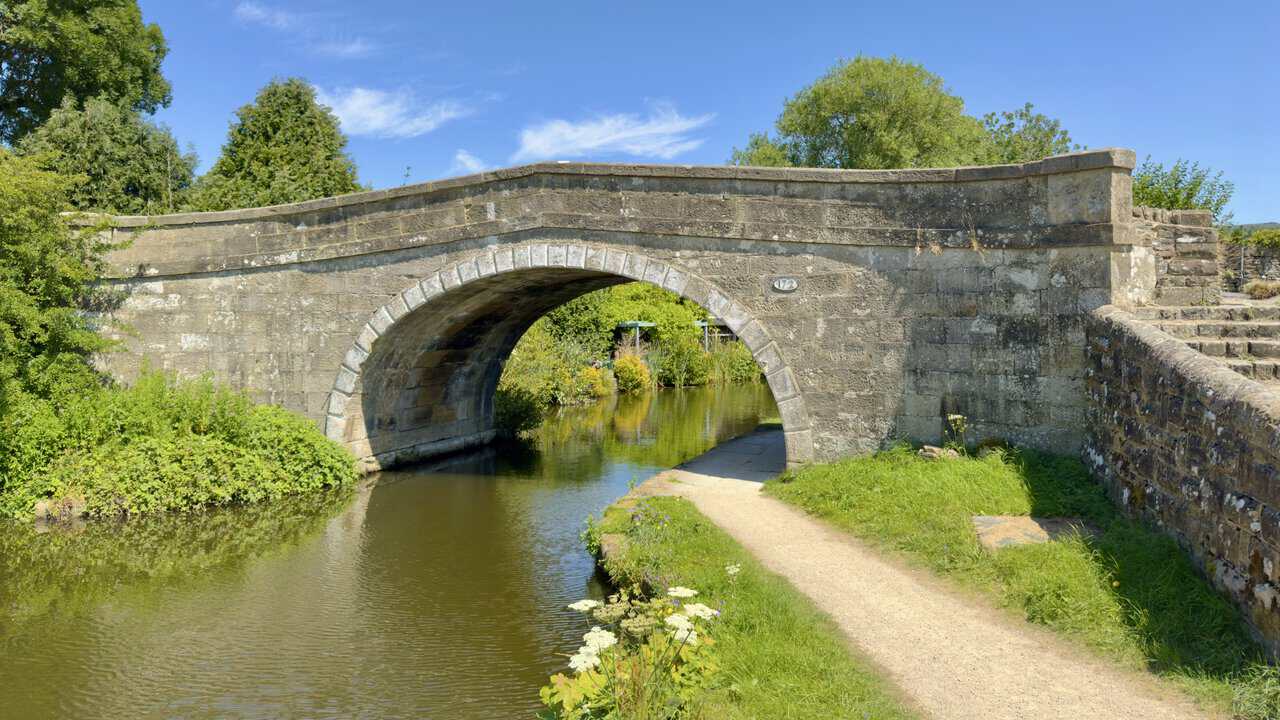 Stone arch of Ray Bridge number 172 over the Leeds and Liverpool Canal, with the towpath beneath.
