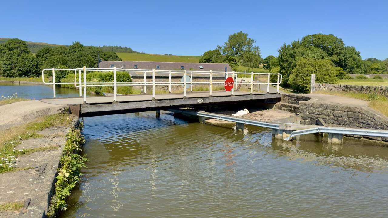 Thorlby Bridge swing bridge on the Skipton walk, with a swan beneath the deck.