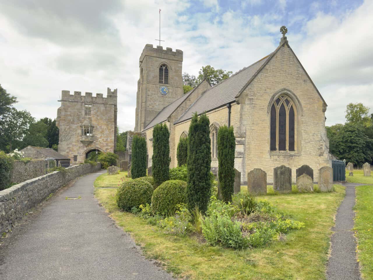 St Nicholas’s Church beside the surviving medieval stone gatehouse known as Marmion Tower in West Tanfield.