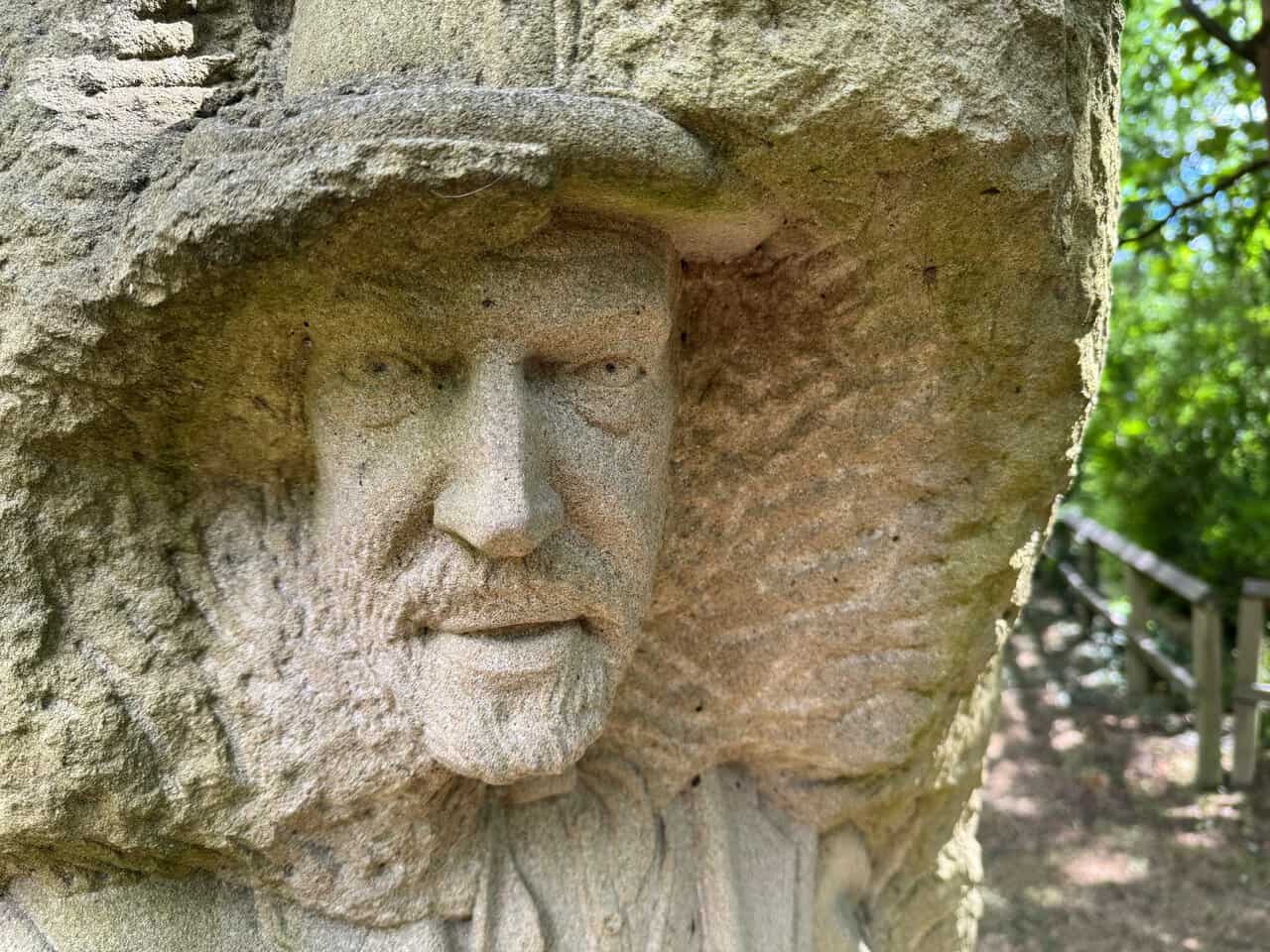 Close view of the lead miner figure carved into a sandstone block, part of the Pillars Past sculpture.