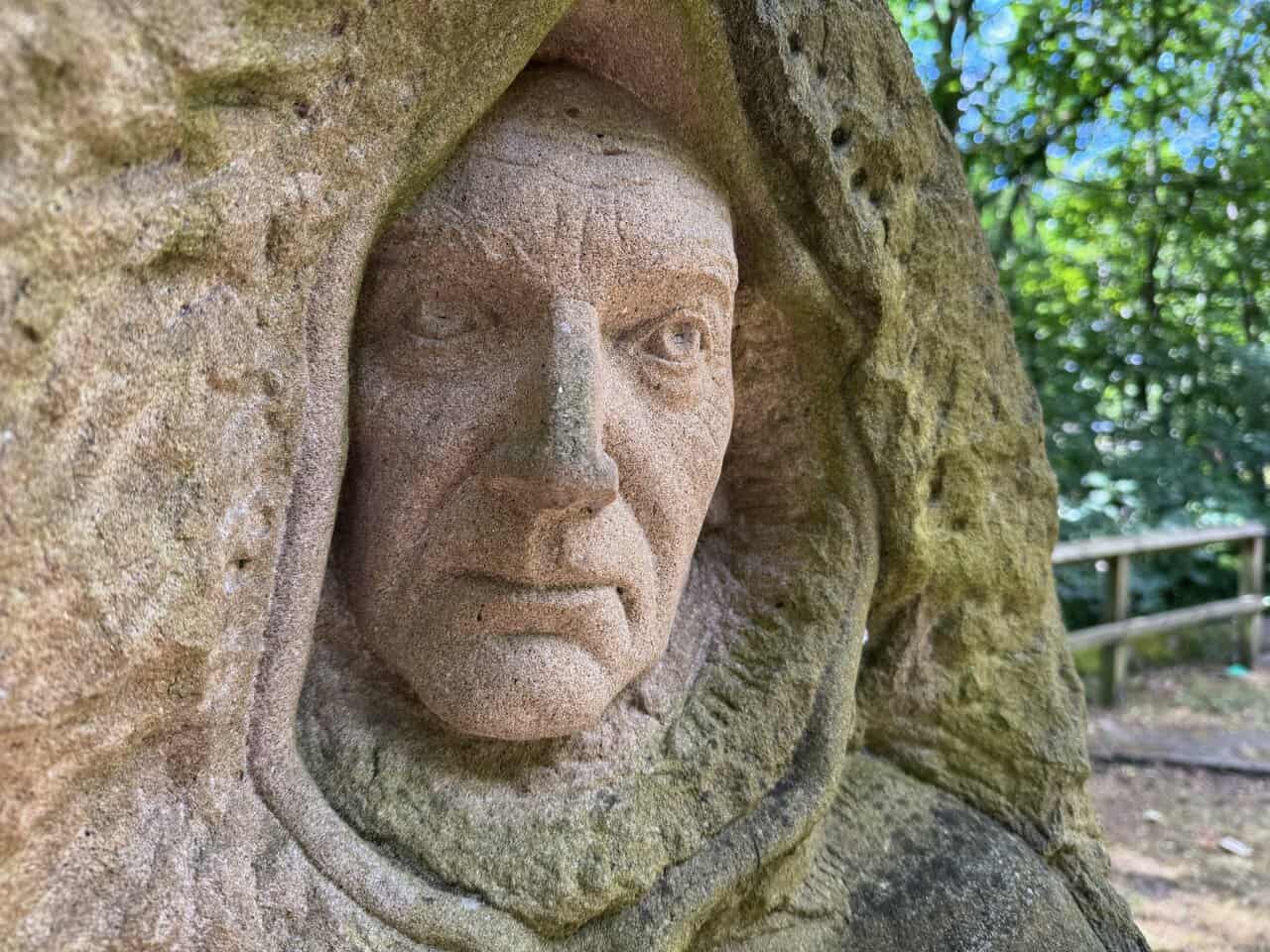Close view of the hooded monk figure on the Yorke's Folly walk, carved into a sandstone block at Pillars Past.