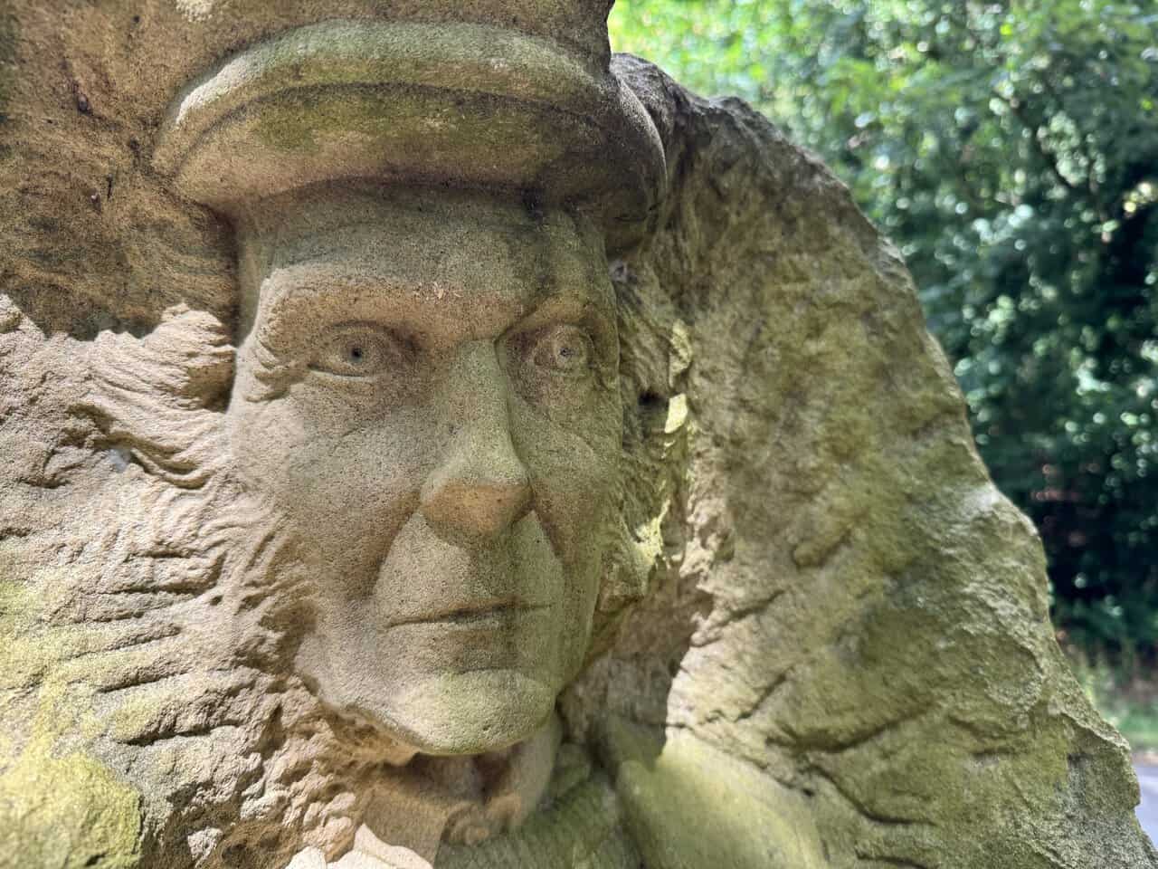 Close view of the farmer figure carved into a sandstone block, part of the Pillars Past sculpture.