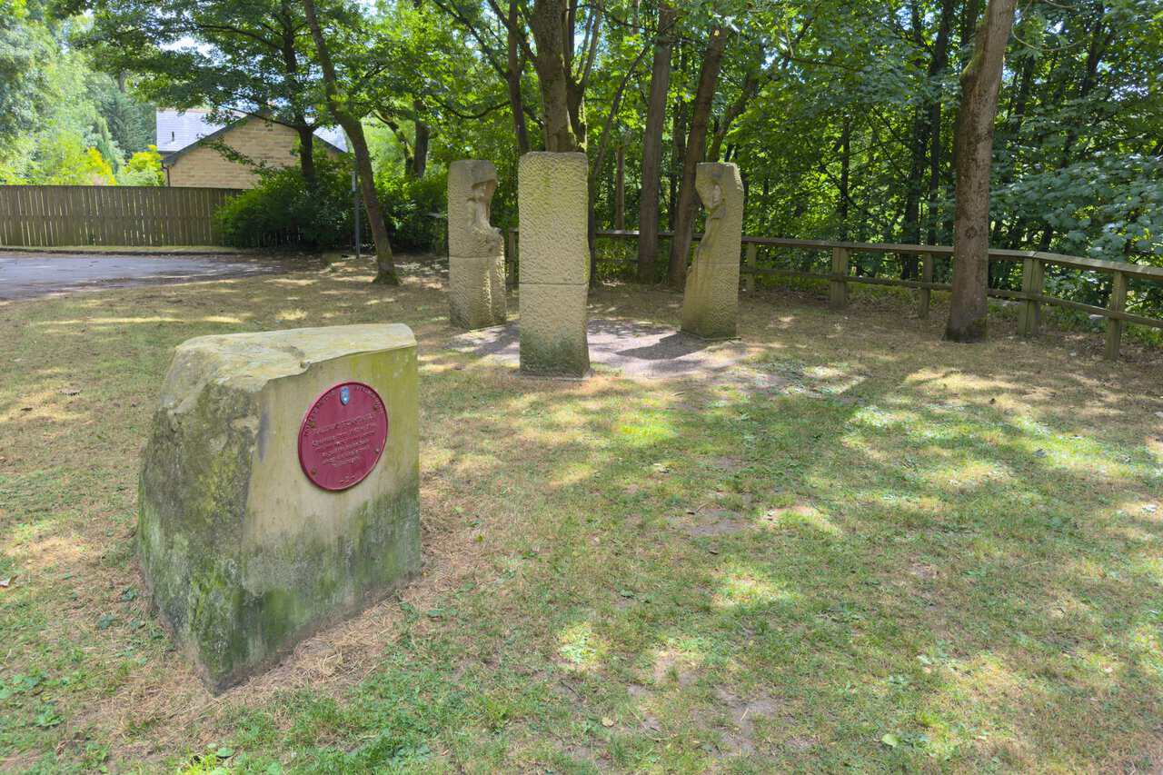 A stone marker with a red plaque on the Yorke's Folly walk, marking the site of the old railway turntable at Pateley Bridge.