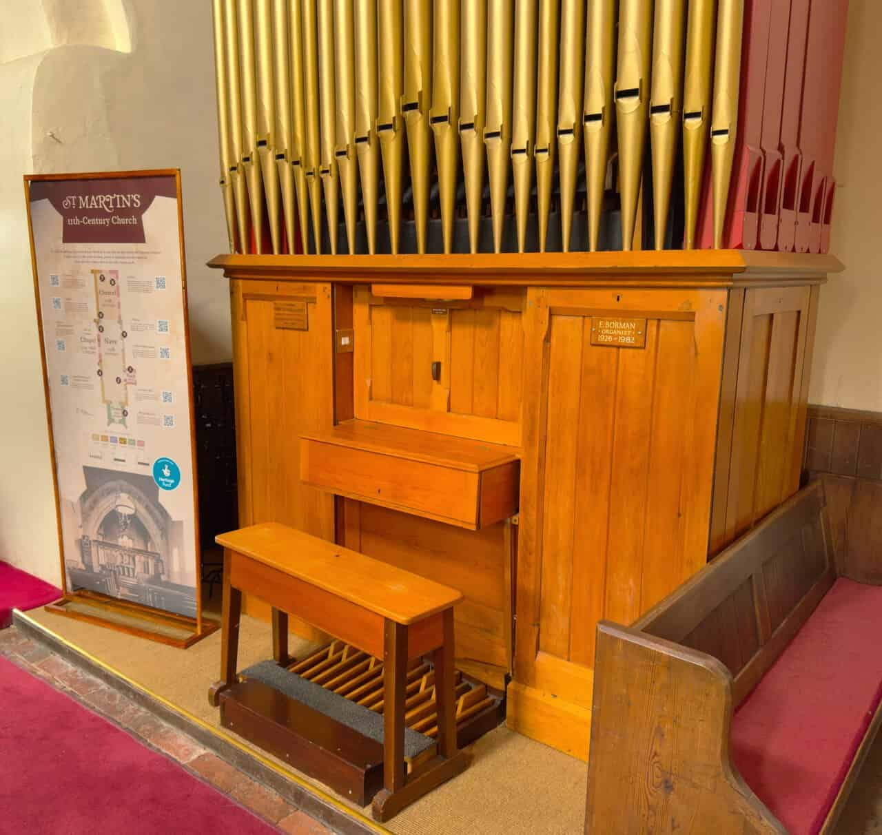 Organ pipes and heritage interpretation board inside St Martin's Church, Bulmer.