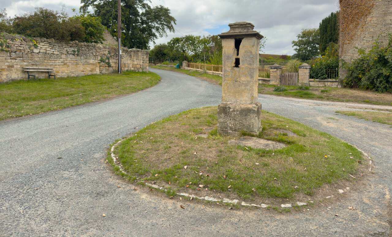 The 18th-century sandstone village pump on the green at Ganthorpe.