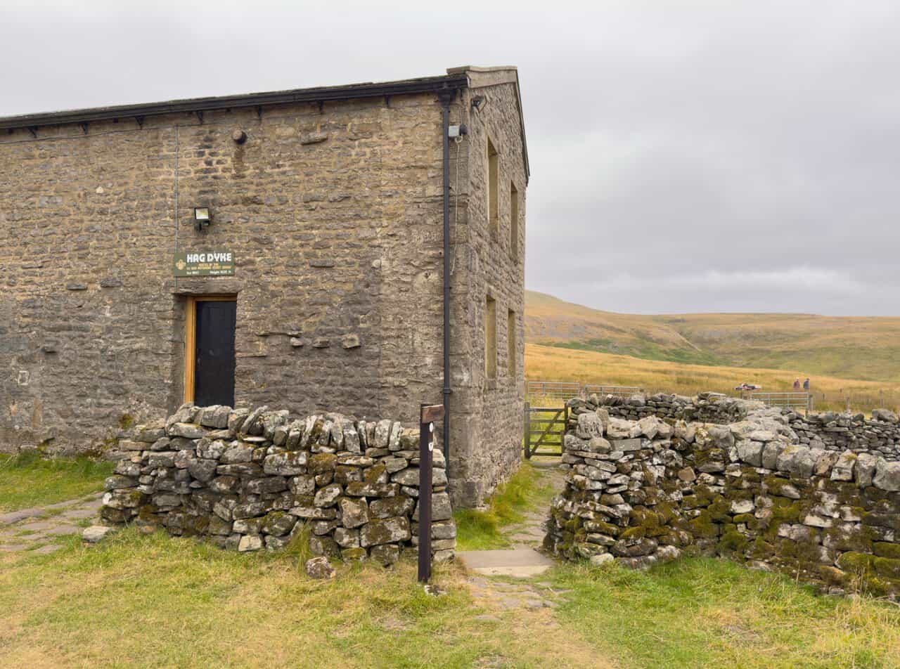 The gable end of Hag Dyke hostel, showing the sign recording its height of 1,525 feet.