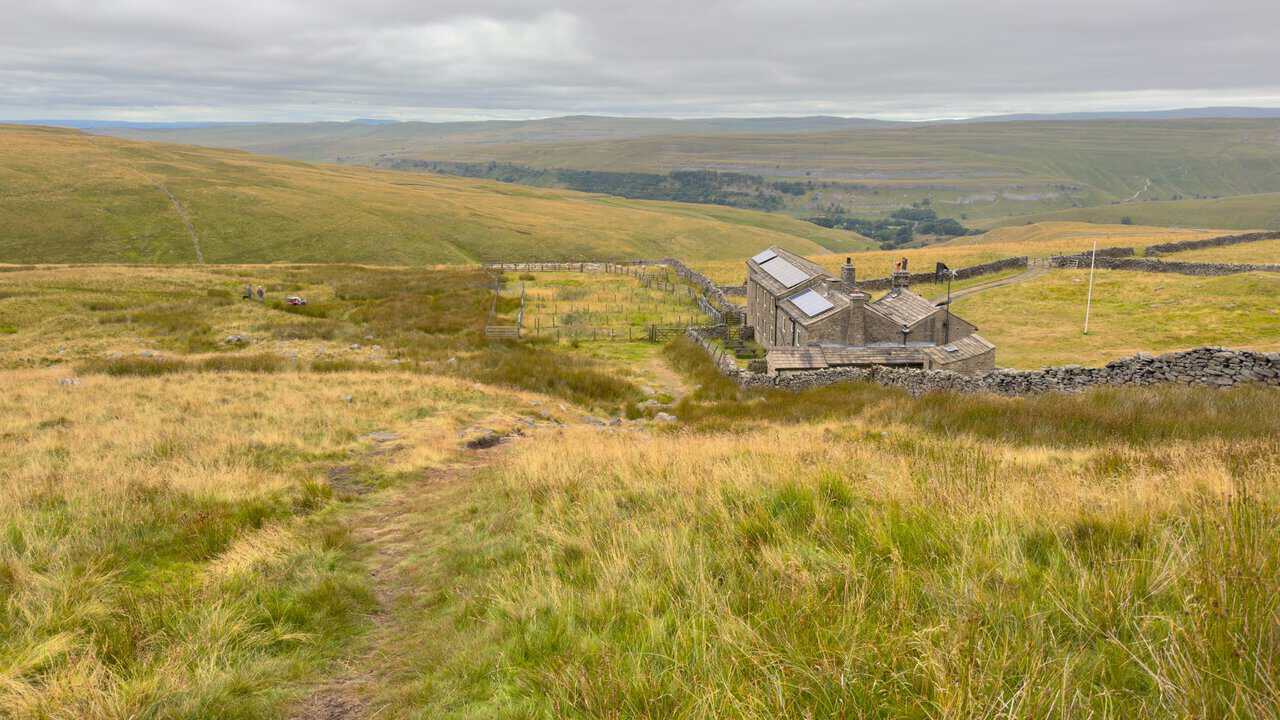 Looking down on Hag Dyke hostel and Wharfedale beyond during the climb on the Great Whernside circular walk.
