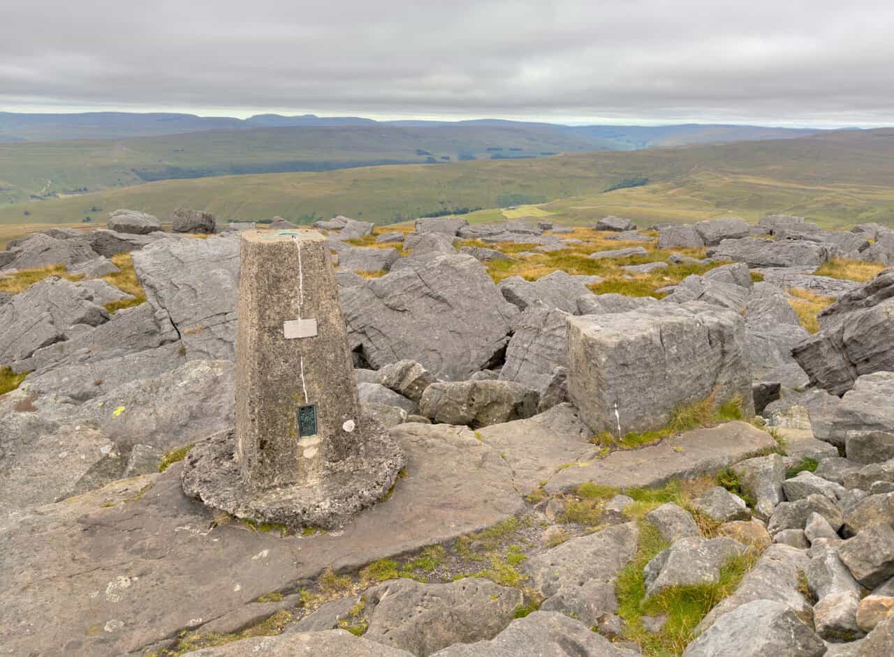The triangulation pillar on Great Whernside, surrounded by weathered blocks of gritstone.