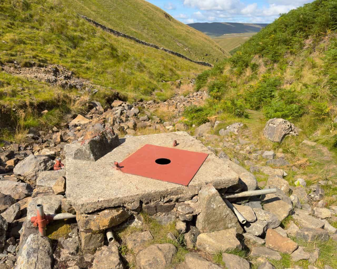 The capped shaft at Providence Pot, with the Dowber Gill Beck valley falling away beyond it.