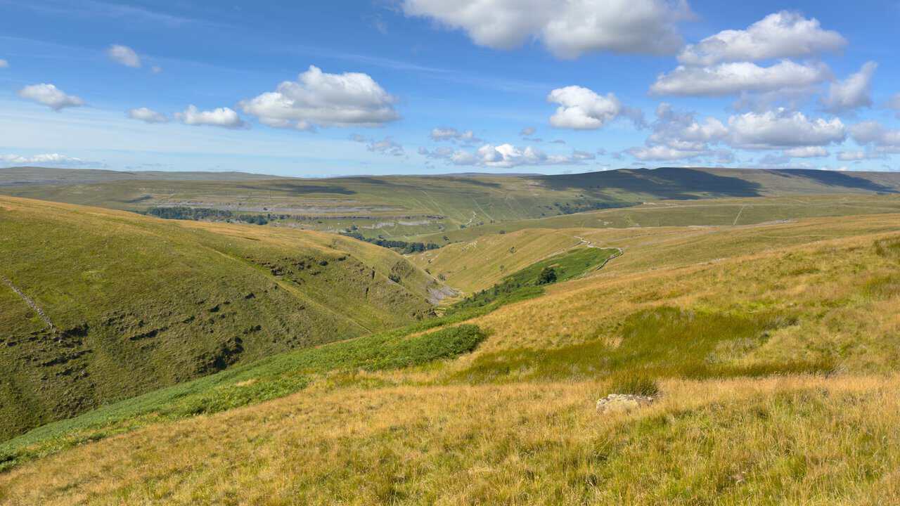 The valley falling away below, with dry stone walls threading across the fells towards the head of Wharfedale.