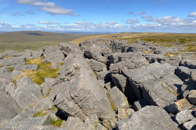 Great slabs of gritstone lying tilted and split apart across the boulder-covered summit visited on both Great Whernside walks.