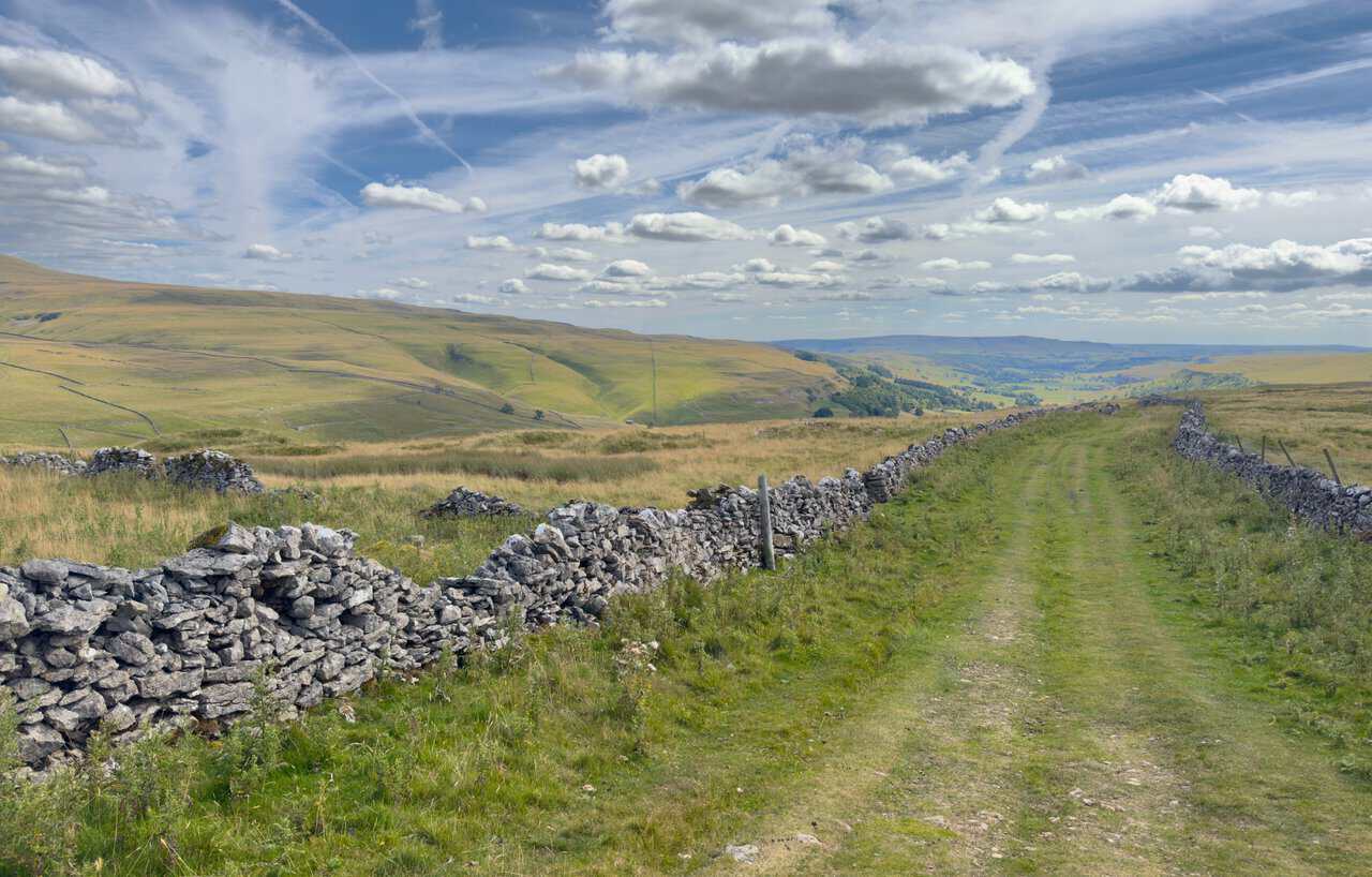 Top Mere Road running as a wide green bridleway enclosed by dry stone walls on both sides.