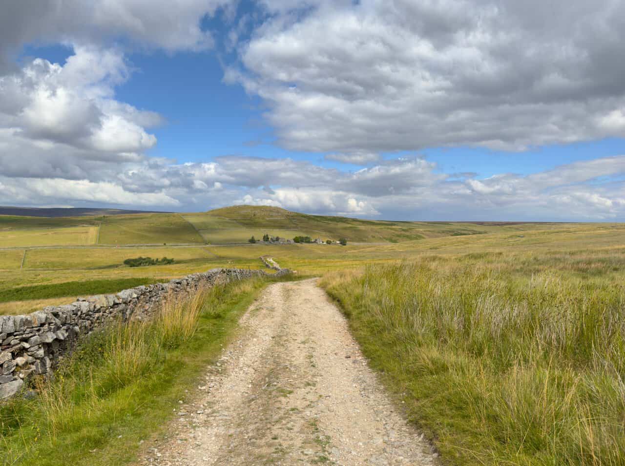 The long stony track of Black Hill Road on the Trollers Gill walk, running north with Nursery Knot in the distance.
