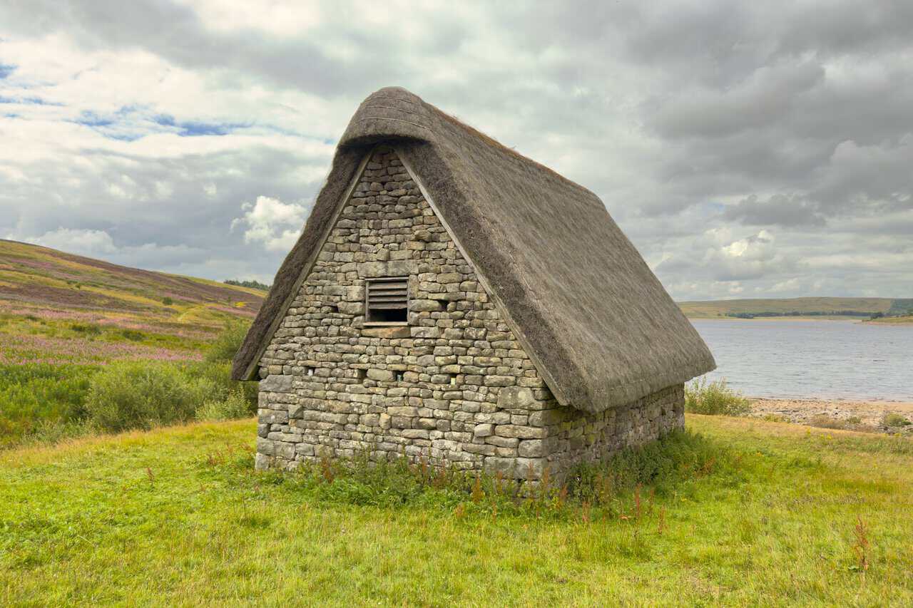 The side view of Grimwith High Laithe, showing the steep pitch of its thatched cruck barn roof.