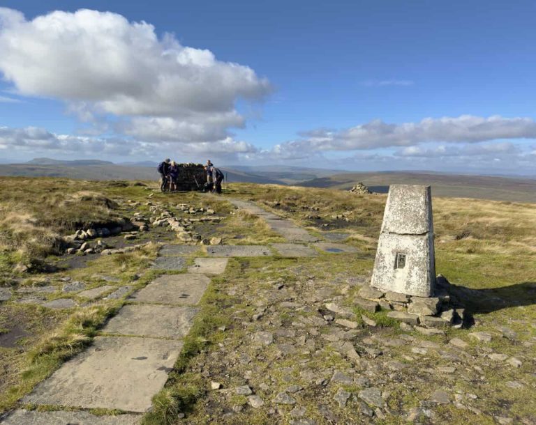 The trig point and stone shelter at the summit of Buckden Pike.