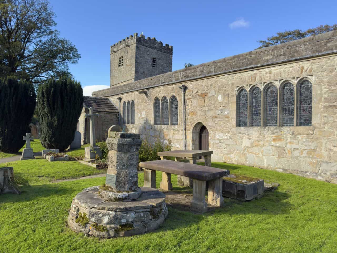 The south side of St Michael and All Angels Church, Hubberholme, with its traceried windows.