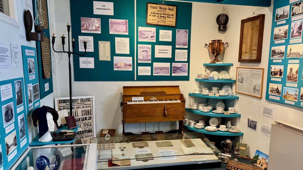 The Religion Room at Nidderdale Museum, with a portable reed organ, shelves of chapel tea crockery and displays on local chapels and Quakers.