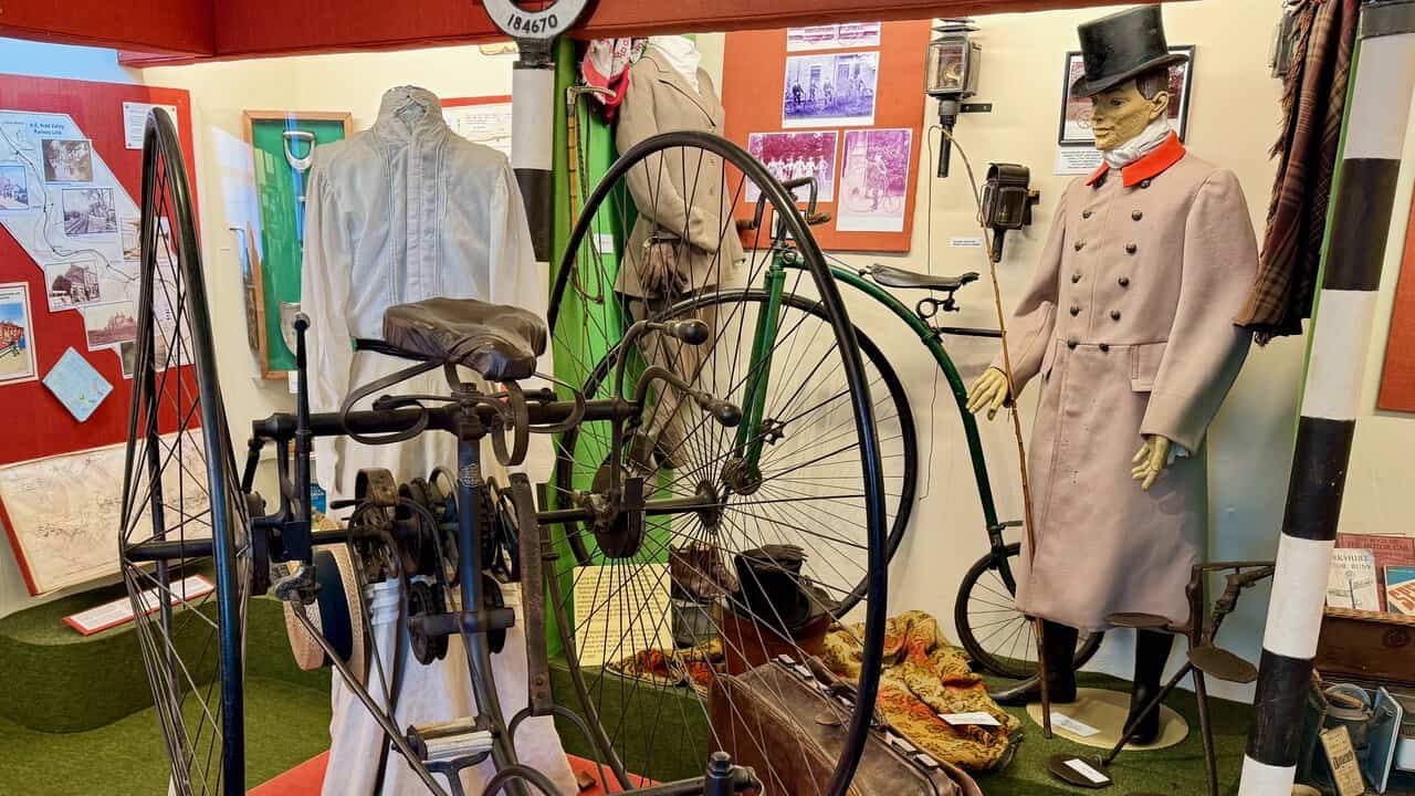 The Transport Room at Nidderdale Museum, with a penny-farthing bicycle, a coachman in livery and a top hat, and old carriage lamps.